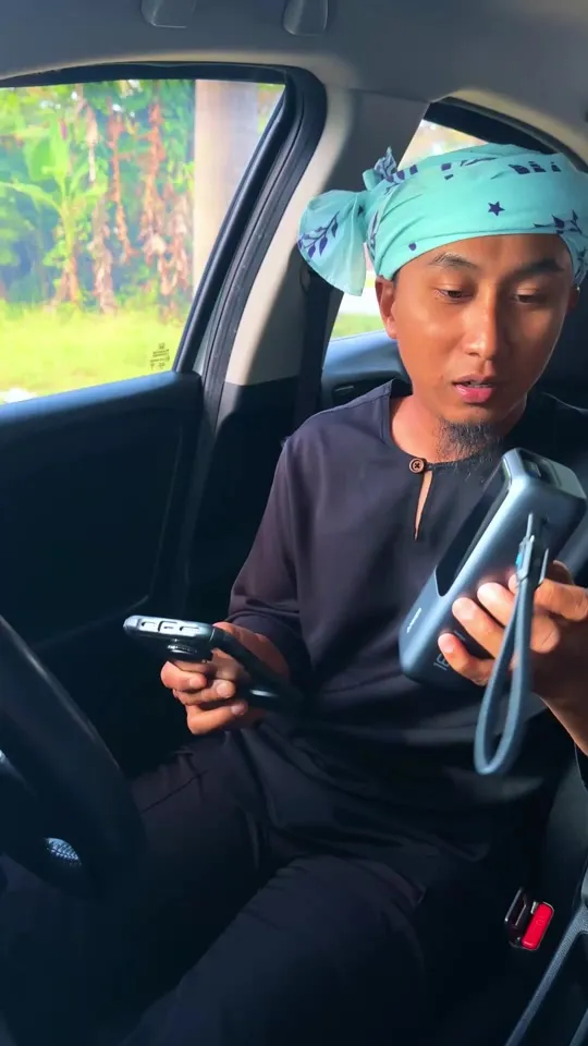 Abe Wea di dalam kereta memegang power bank Anker