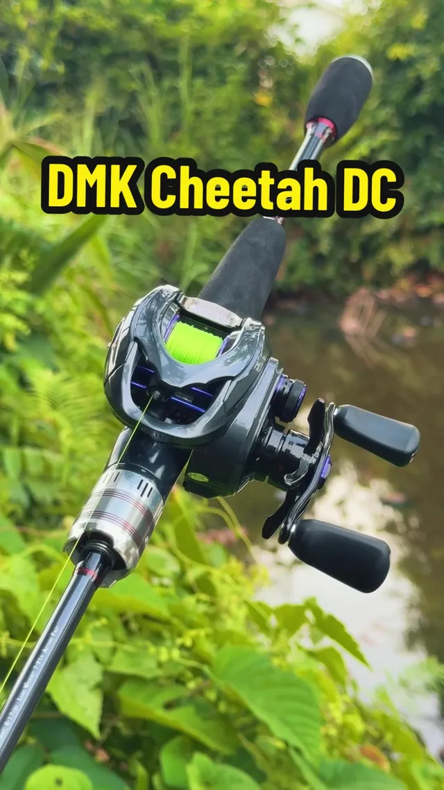 Reel DMK Cheetah pada joran, berlatarkan pokok di tepi air