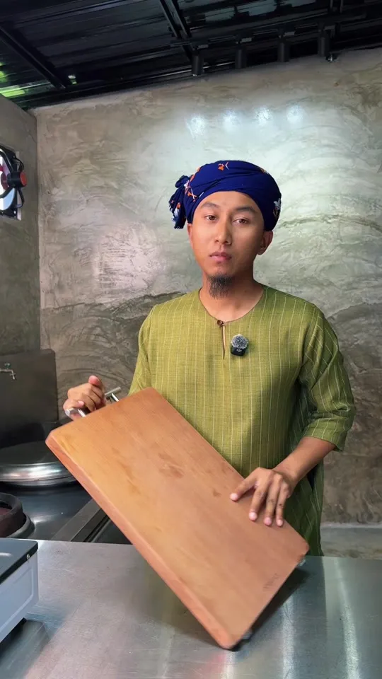 Abe Wea di dapur memegang papan pemotong kayu Ecowin yang besar