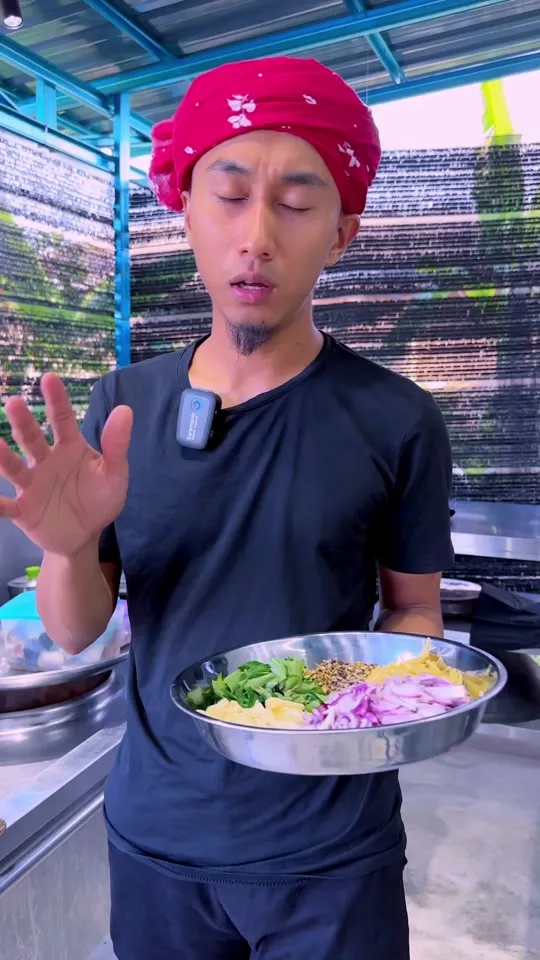 Abe Wea memegang dulang keluli berisi bahan yang sudah disiapkan di dapur