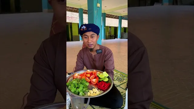 Abe Wea duduk dengan dulang tomato, limau, daun ketumbar, bawang putih dan cili merah