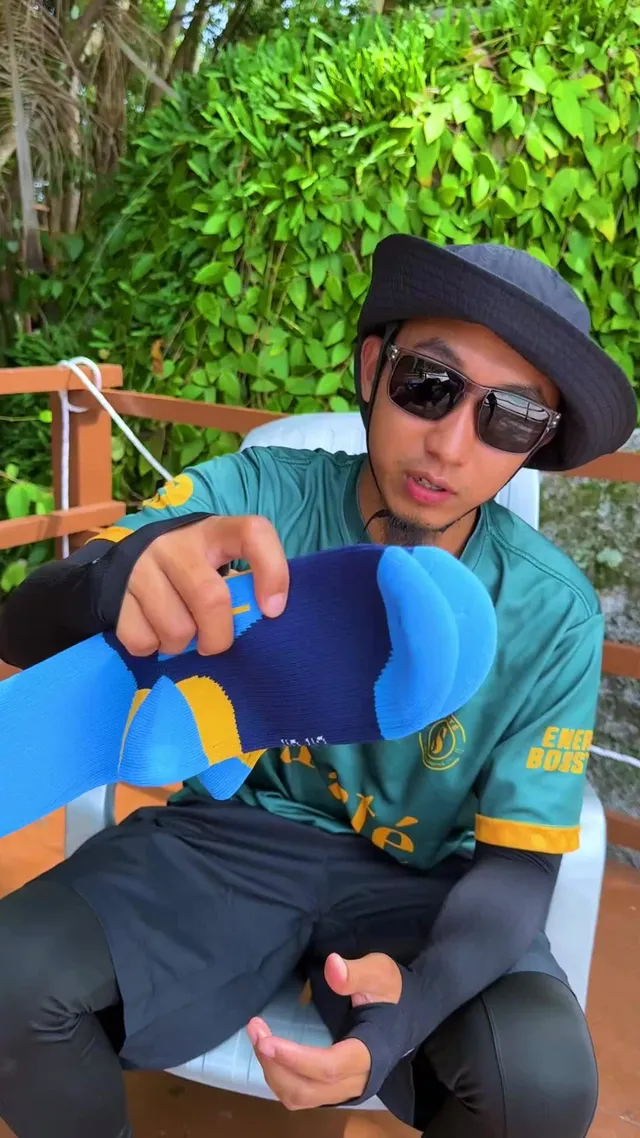 Abe Wea memegang sepasang stoking kalis air berwarna biru