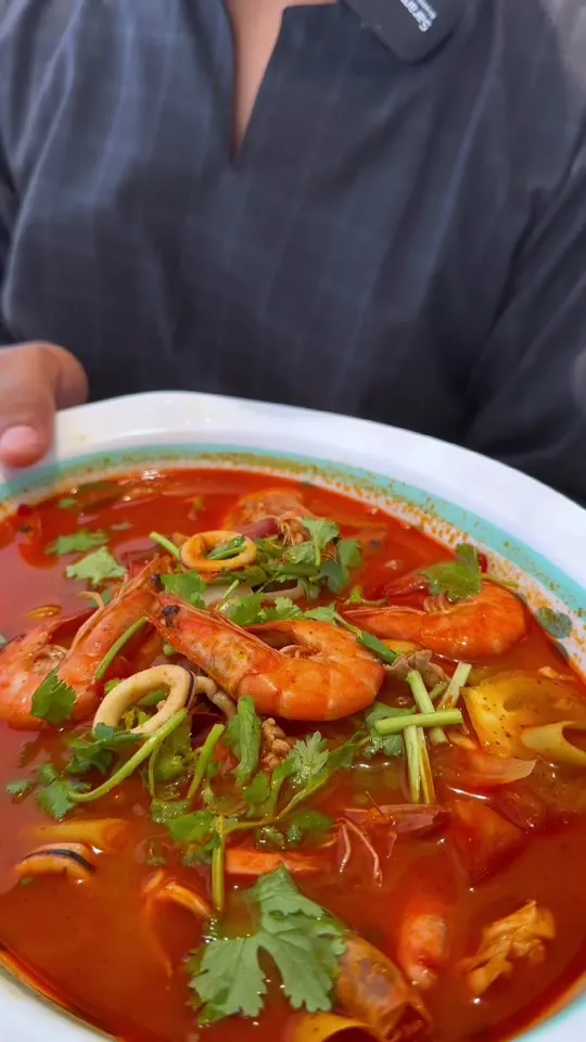 Semangkuk tomyam campur dengan udang, sotong dan daun ketumbar
