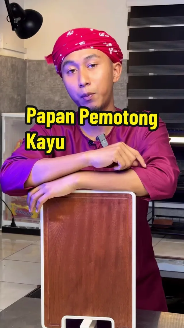 Abe Wea bersandar pada papan pemotong kayu di dapur