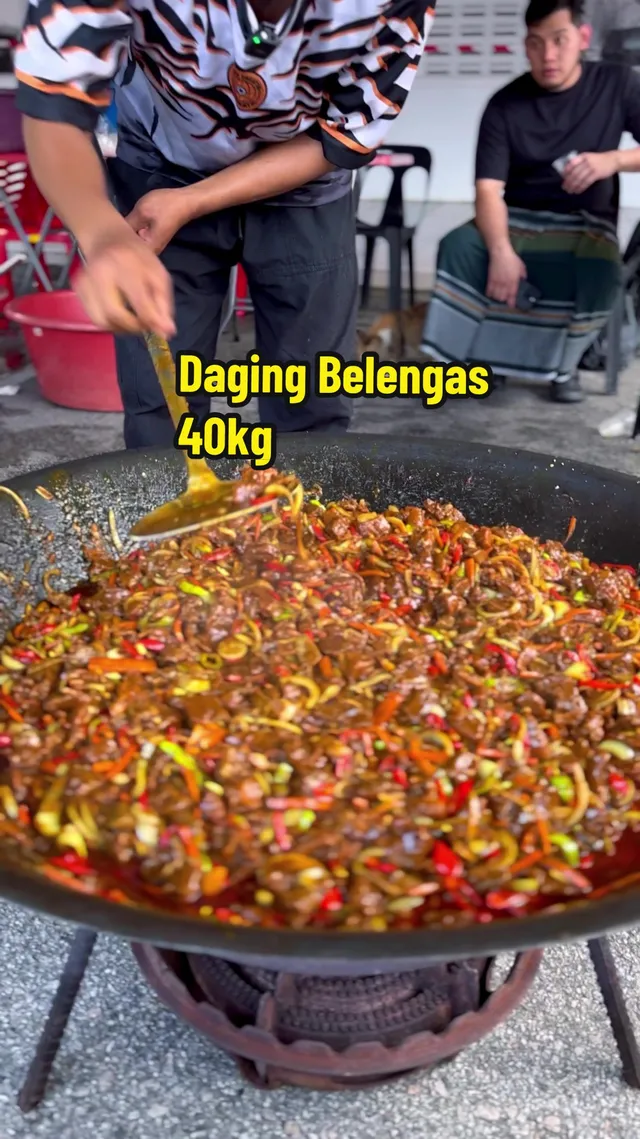 Daging goreng belengas dikacau dalam kawah besar, dengan teks 'Daging Belengas 40kg'