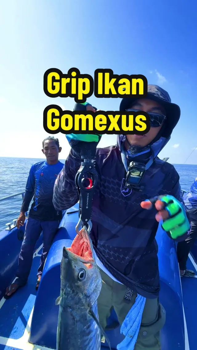 Abe Wea di atas bot memegang ikan dengan grip ikan Gomexus