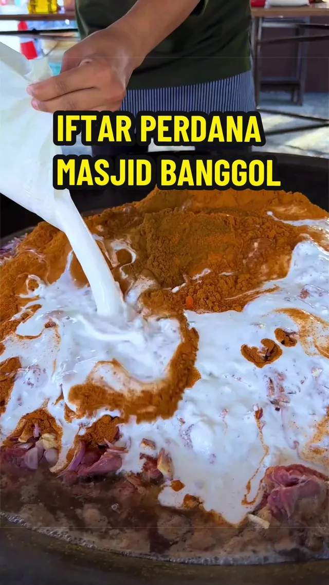 Cecair putih dituang ke dalam kawah berisi daging dan rempah, dengan teks 'Iftar Perdana Masjid Banggol'