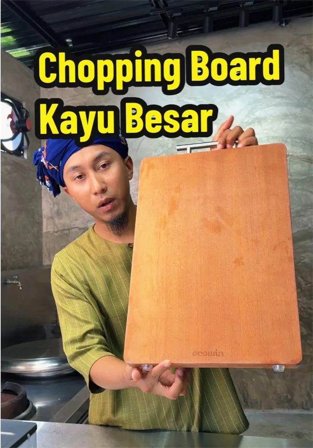 Abe Wea mengangkat papan pemotong kayu yang besar di dapur