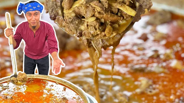 Abe Wea memegang pengacau panjang di sebelah kawah gulai, dengan senduk gulai daging di hadapan