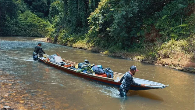 Perahu sarat barang ditolak menyusuri sungai dalam hutan Ulu Sungai Lebir