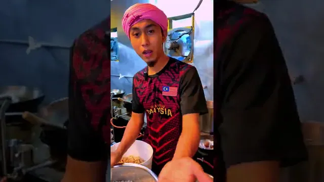 Abe Wea bercakap di hadapan stesen kuali di dapur